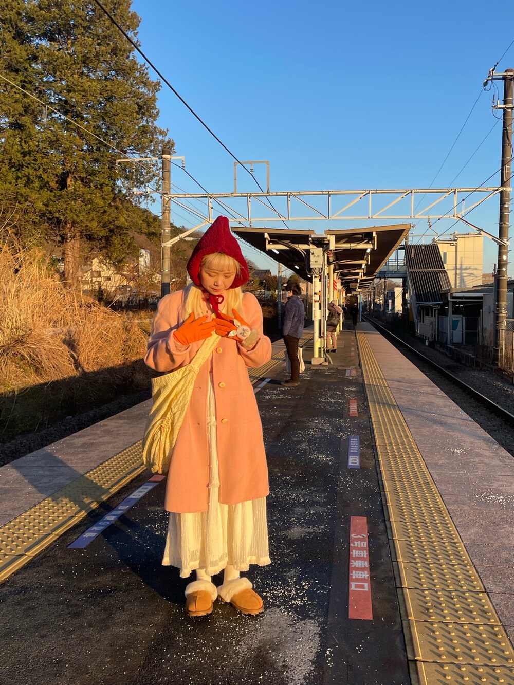 イエロー系のショルダーバッグ、ベージュ系のその他シューズを着用したレディースの冬コーディネートの2枚目の写真