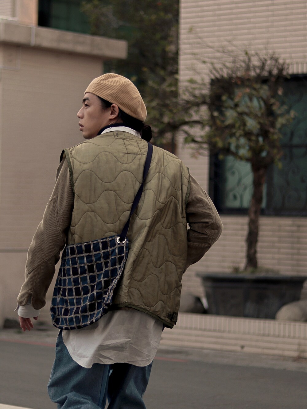 ベージュ系のノーカラージャケットを着用したメンズの春コーディネートの5枚目の写真