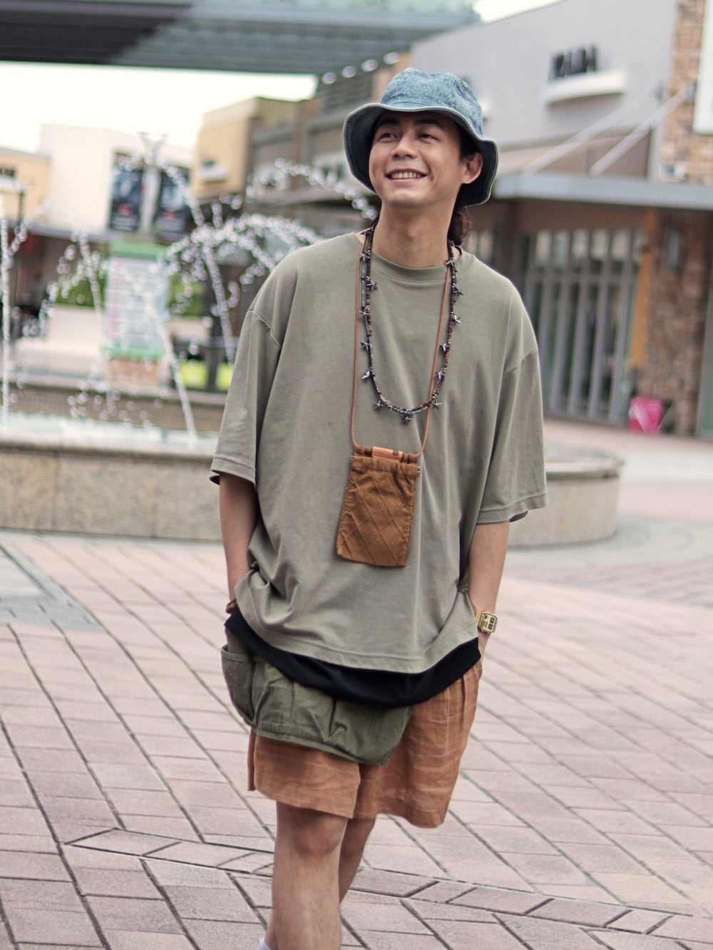 オレンジ系のカーゴパンツを着用したメンズの夏コーディネートの2枚目の写真