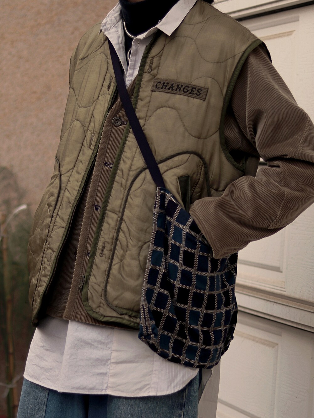 ベージュ系のノーカラージャケットを着用したメンズの春コーディネートの4枚目の写真