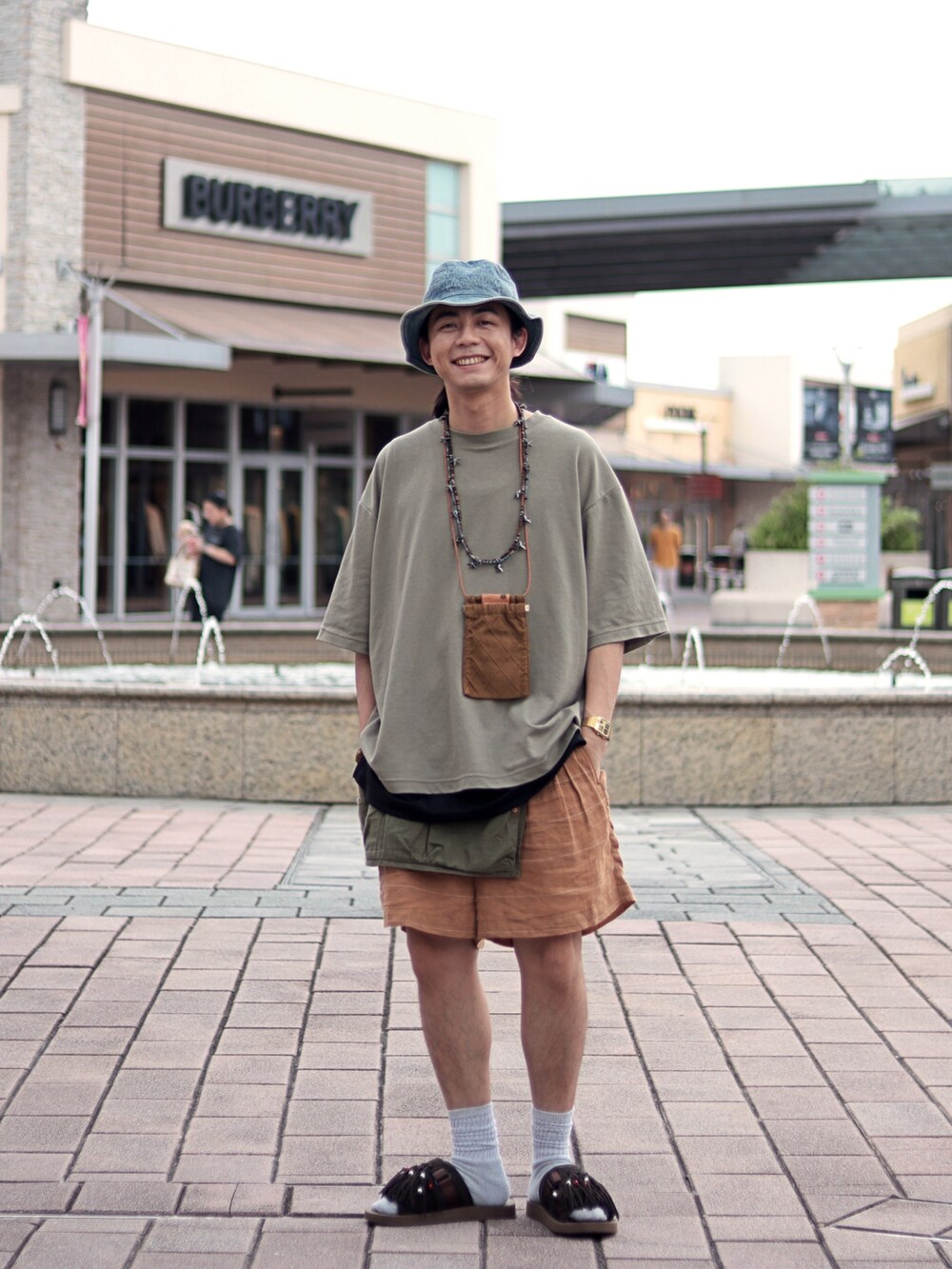 オレンジ系のカーゴパンツを着用したメンズの夏コーディネートの5枚目の写真