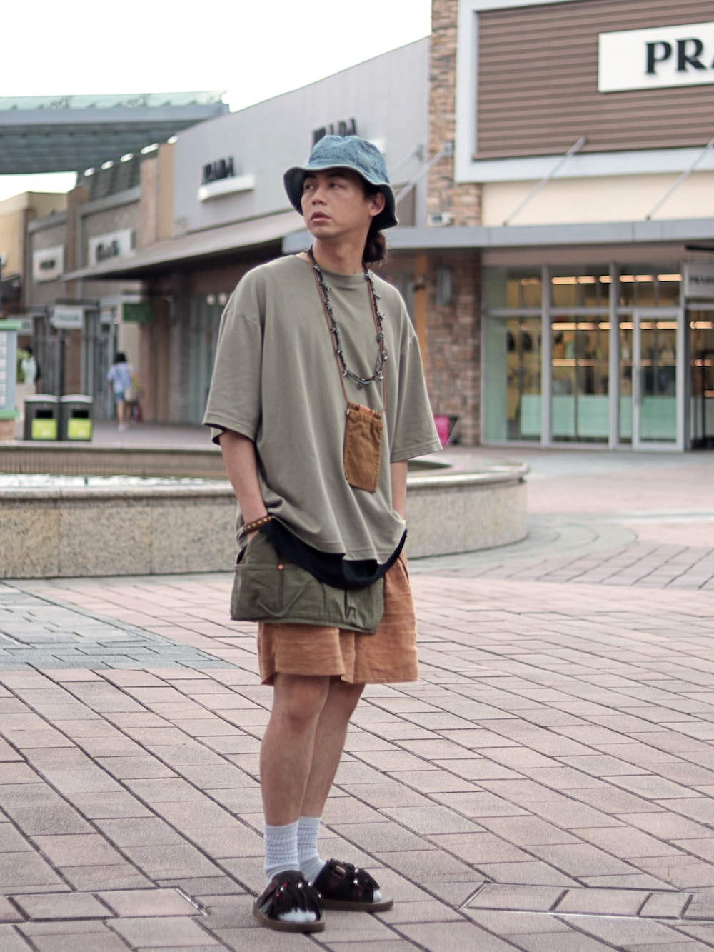 オレンジ系のカーゴパンツを着用したメンズの夏コーディネートの3枚目の写真