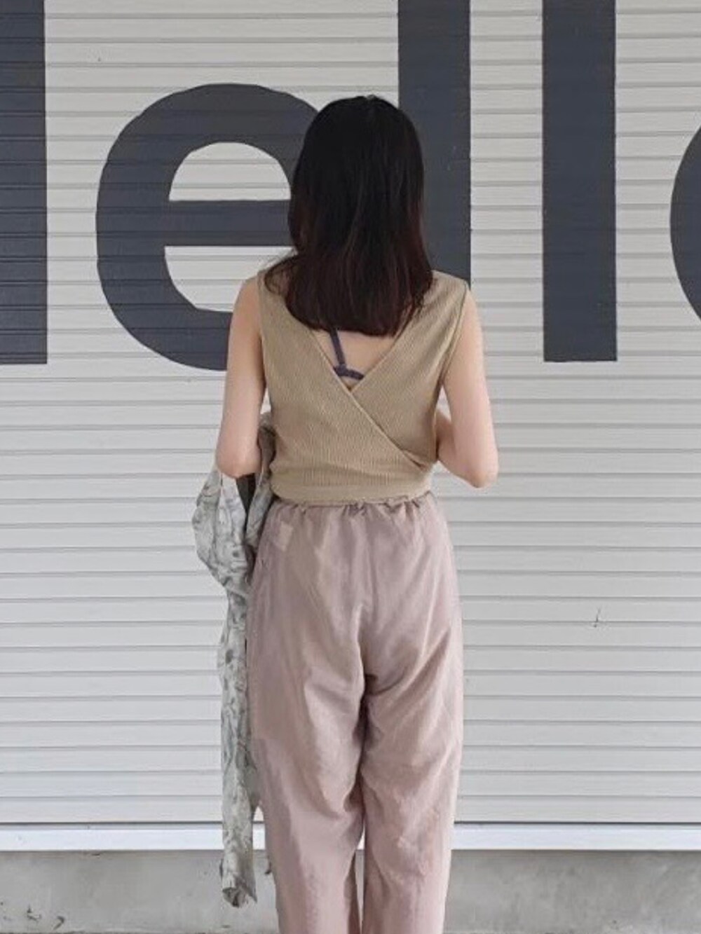 ベージュ系のその他パンツ、ブラウン系のサンダル、ベージュ系のTシャツ/カットソーを着用したレディースの夏コーディネートの2枚目の写真