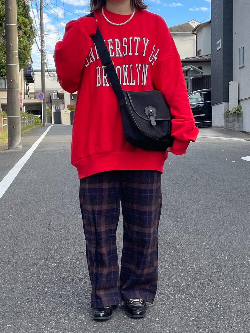 レッド系のスウェットを着用したレディースの冬コーディネートの2枚目の写真