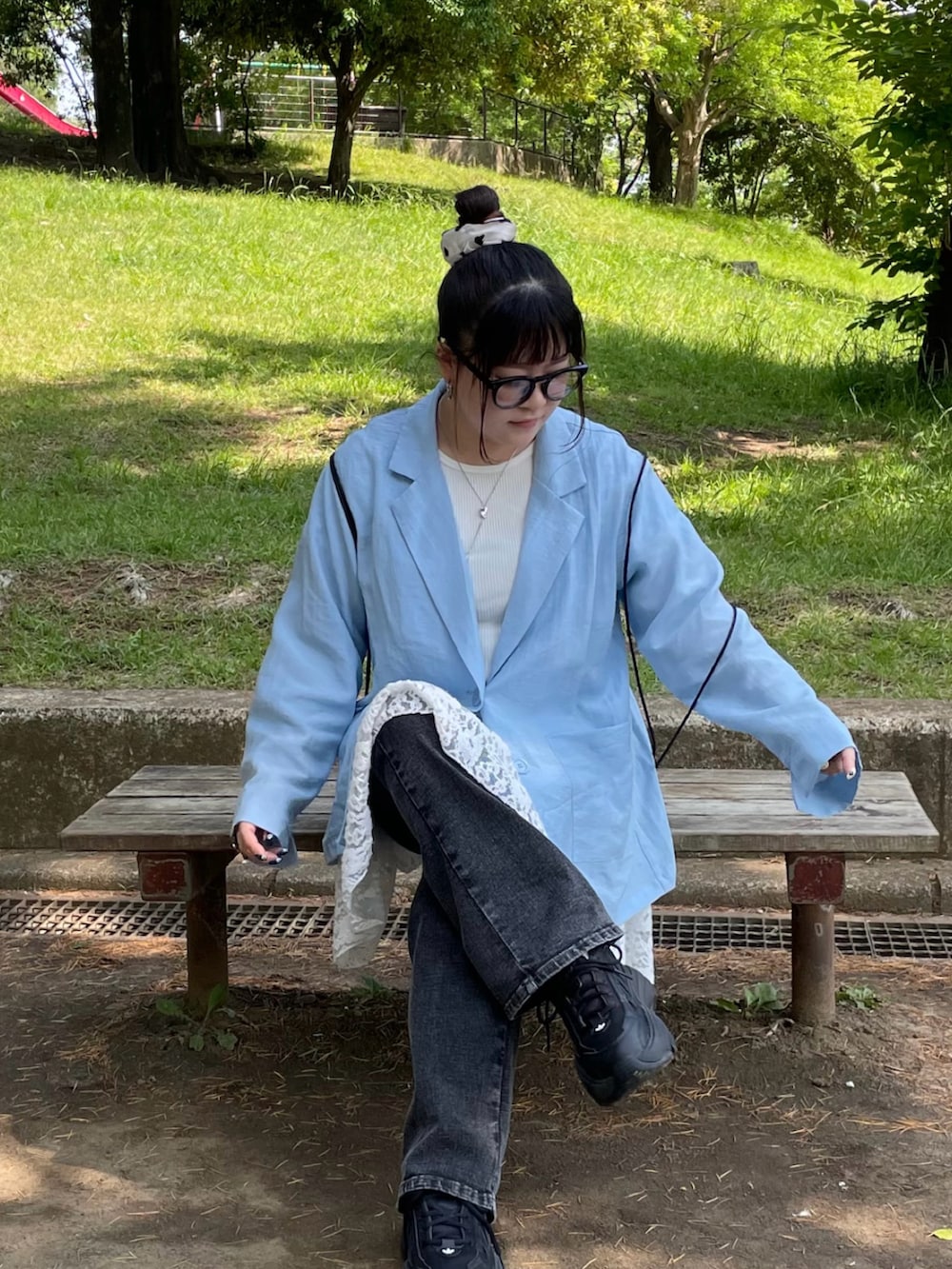 ブルー系のテーラードジャケット、ブラック系のバックパック/リュック、ブラック系のスニーカーを着用したレディースの夏コーディネートの3枚目の写真