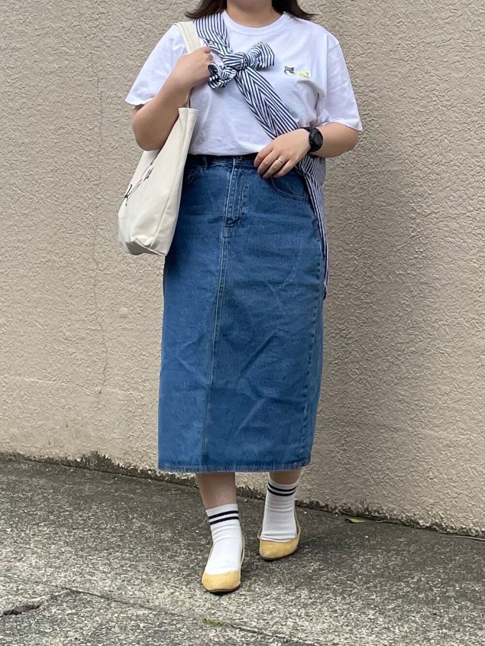 ホワイト系のTシャツ/カットソー、ブルー系のデニムスカート、イエロー系のパンプスを着用したレディースの夏コーディネートの4枚目の写真