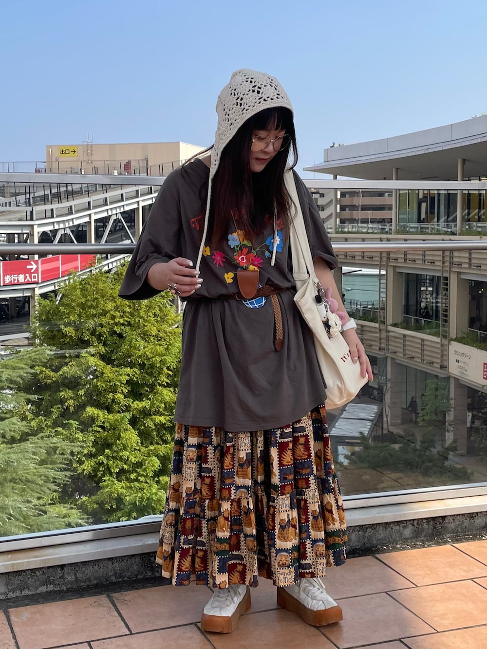 グレー系のTシャツ/カットソー、ホワイト系のスニーカー、ベージュ系のトートバッグを着用したレディースの秋コーディネートの2枚目の写真
