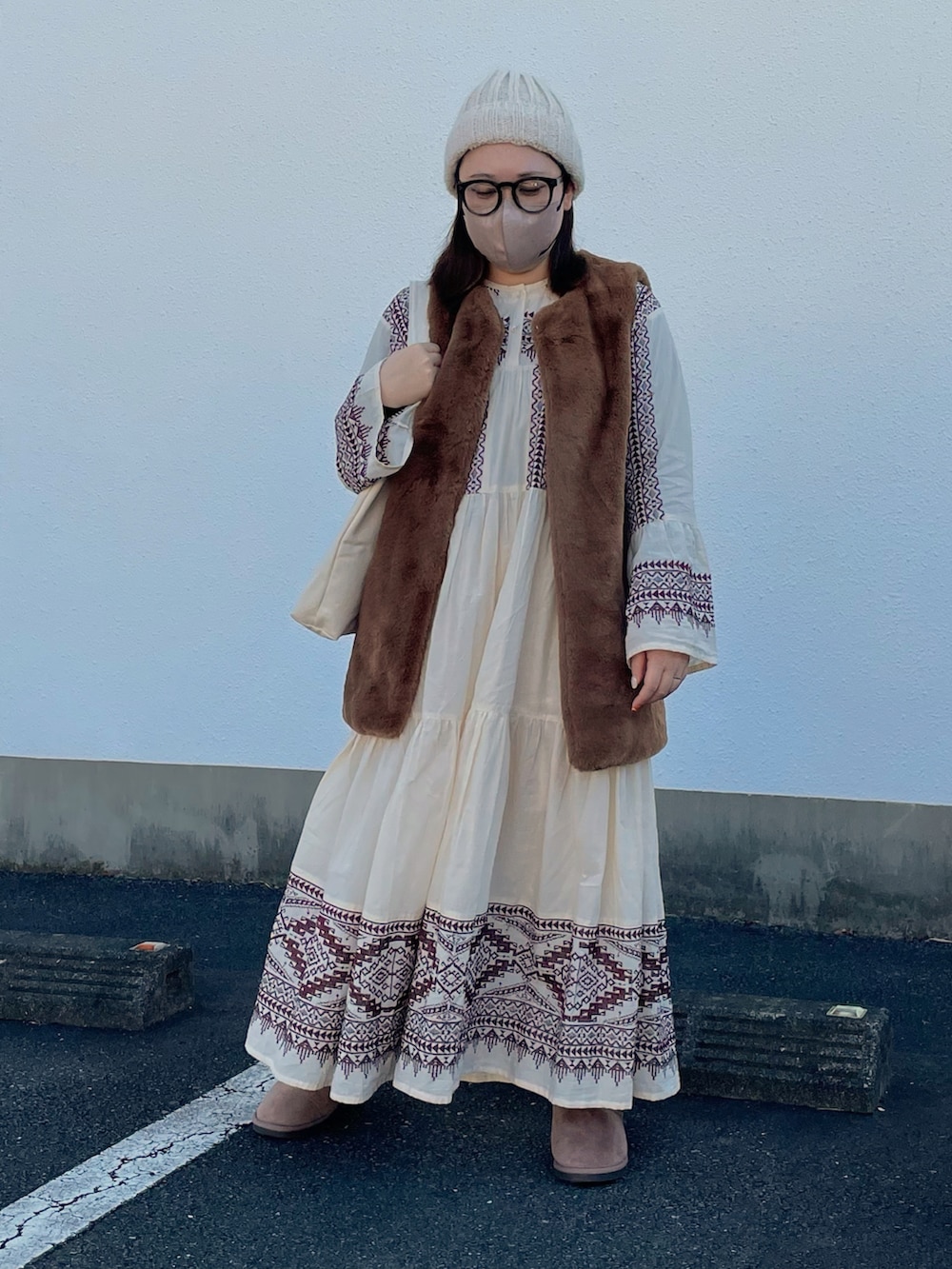 ホワイト系のワンピース、ブラウン系のベスト、ホワイト系のトートバッグを着用したレディースの秋コーディネートの2枚目の写真