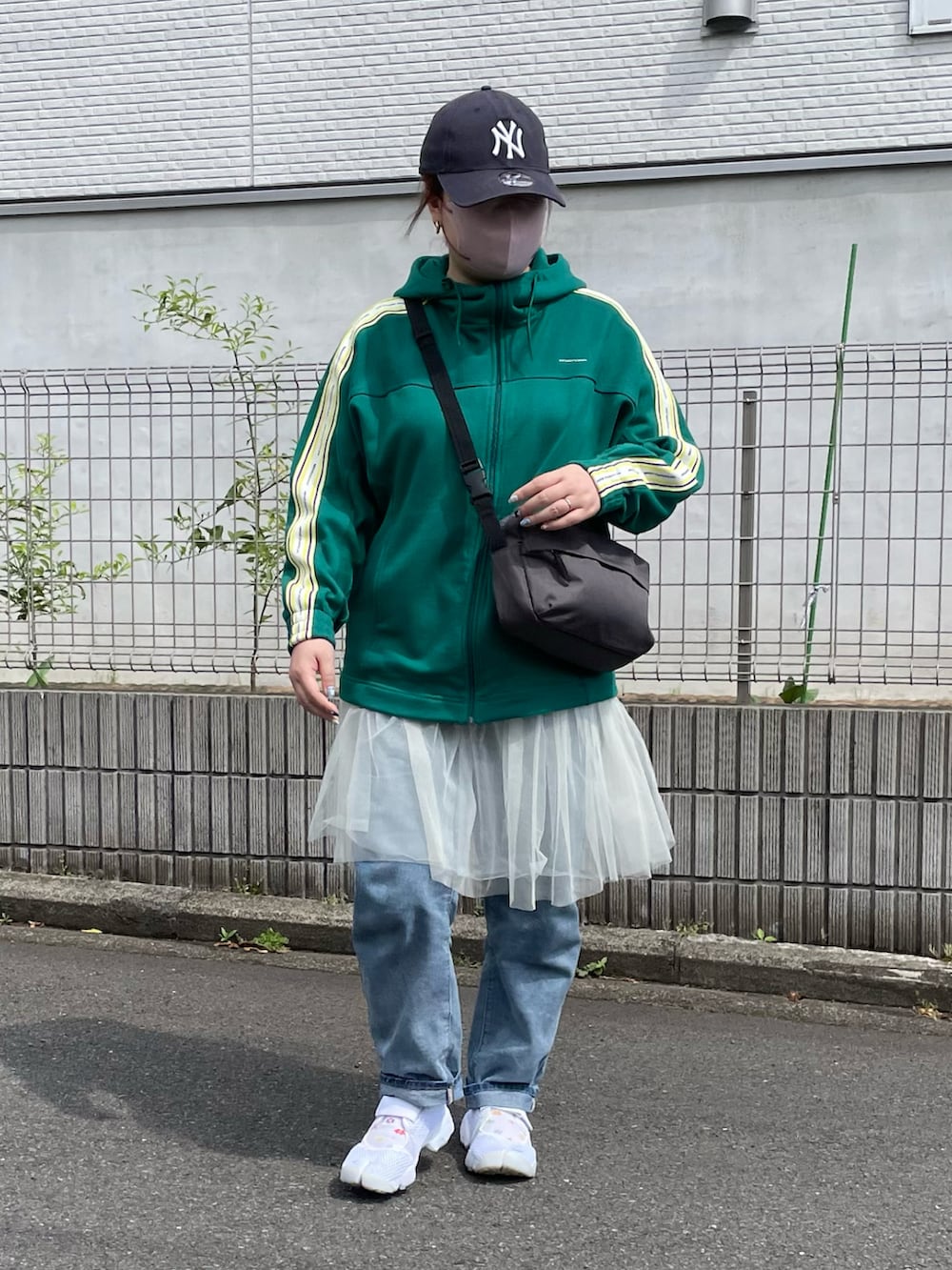 ホワイト系のスカート、ホワイト系のサンダル、ブルー系のキャップを着用したレディースの春コーディネートの3枚目の写真