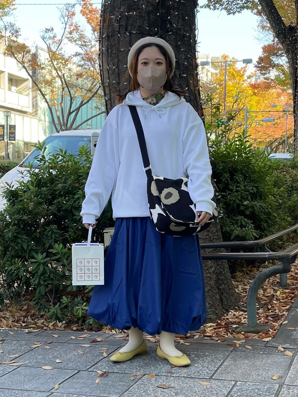 ブルー系のスカート、イエロー系のバレエシューズを着用したレディースの秋コーディネートの2枚目の写真