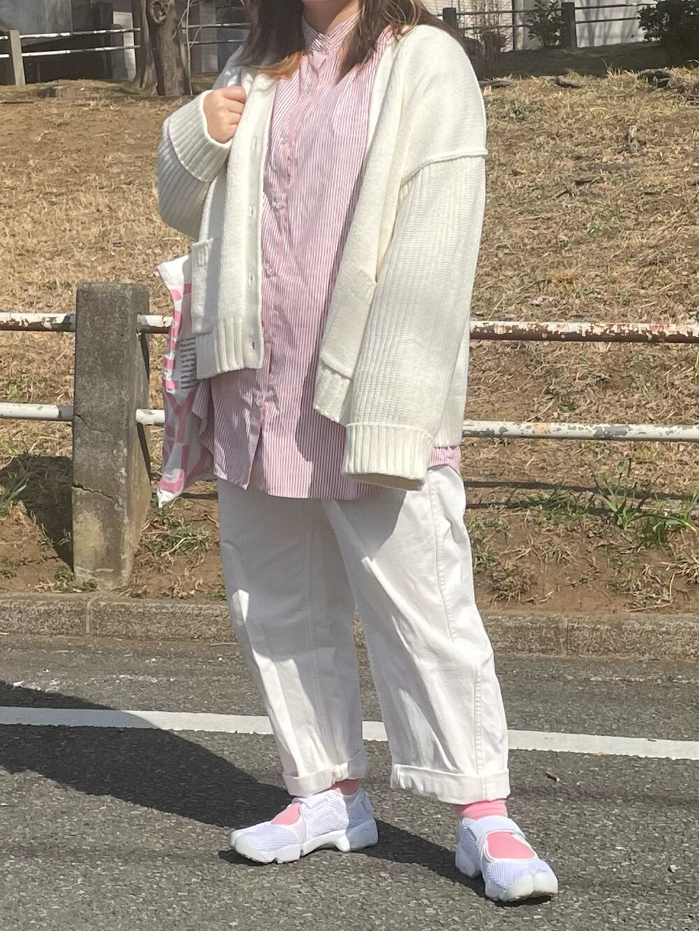 レッド系のシャツ/ブラウス、ホワイト系のカーディガン/ボレロ、ホワイト系のトートバッグを着用したレディースの春コーディネートの2枚目の写真