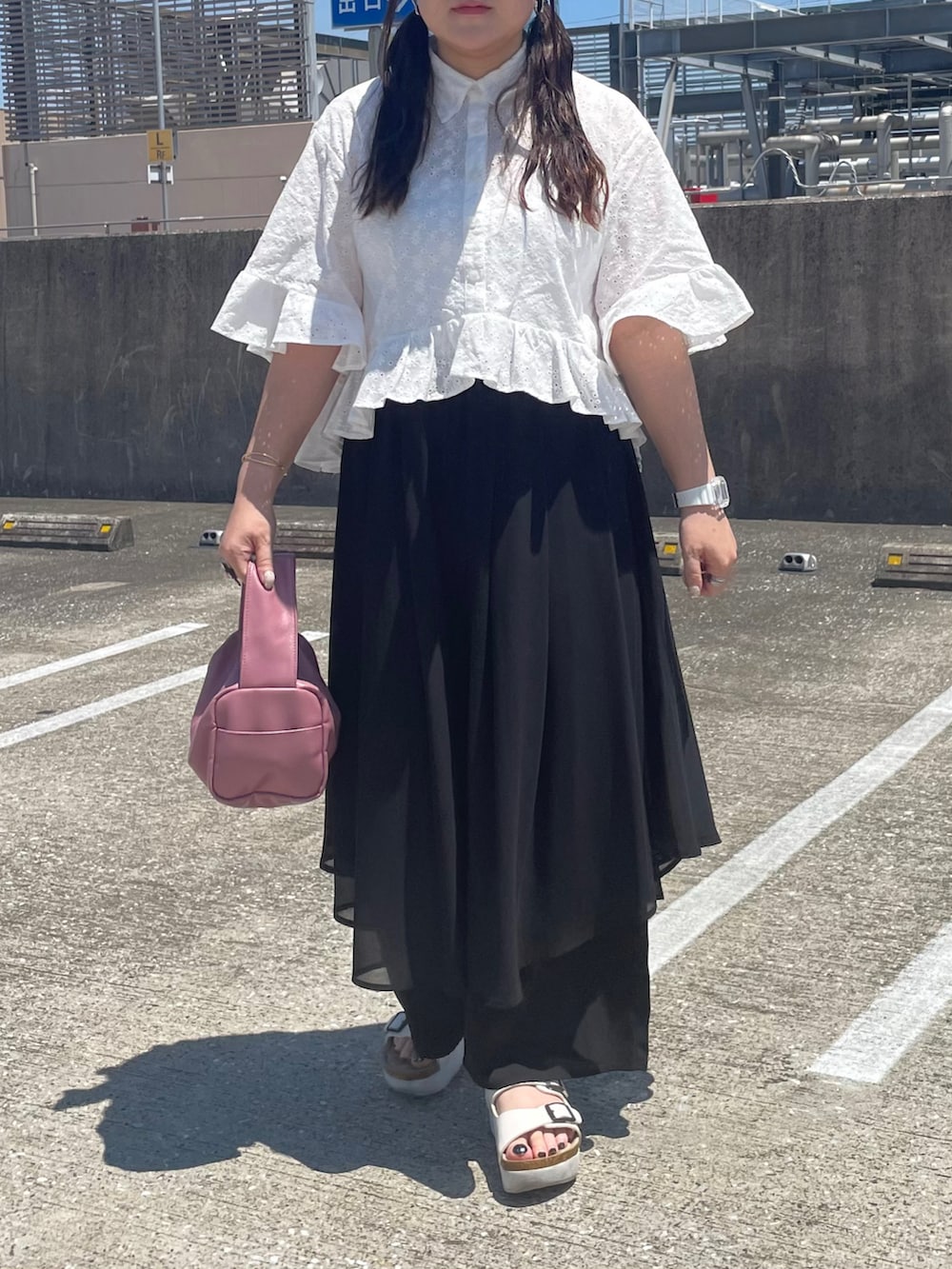 ブラック系のその他パンツ、ピンク系のボストンバッグ、ホワイト系のアナログ腕時計を着用したレディースの夏コーディネートの2枚目の写真