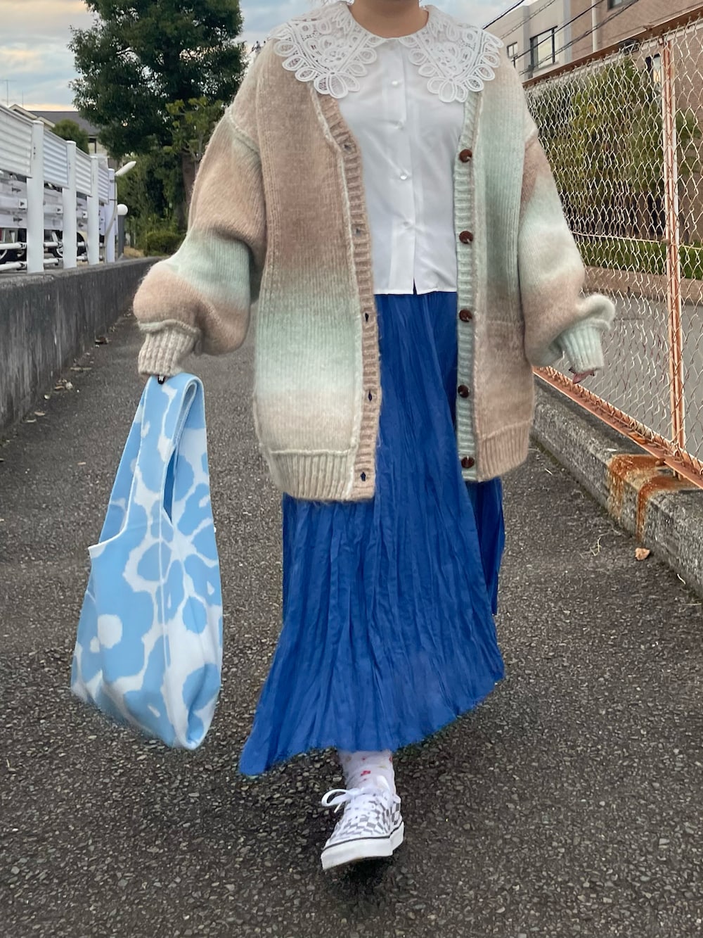 グリーン系のカーディガン/ボレロ、グレー系のスニーカーを着用したレディースの秋コーディネートの2枚目の写真