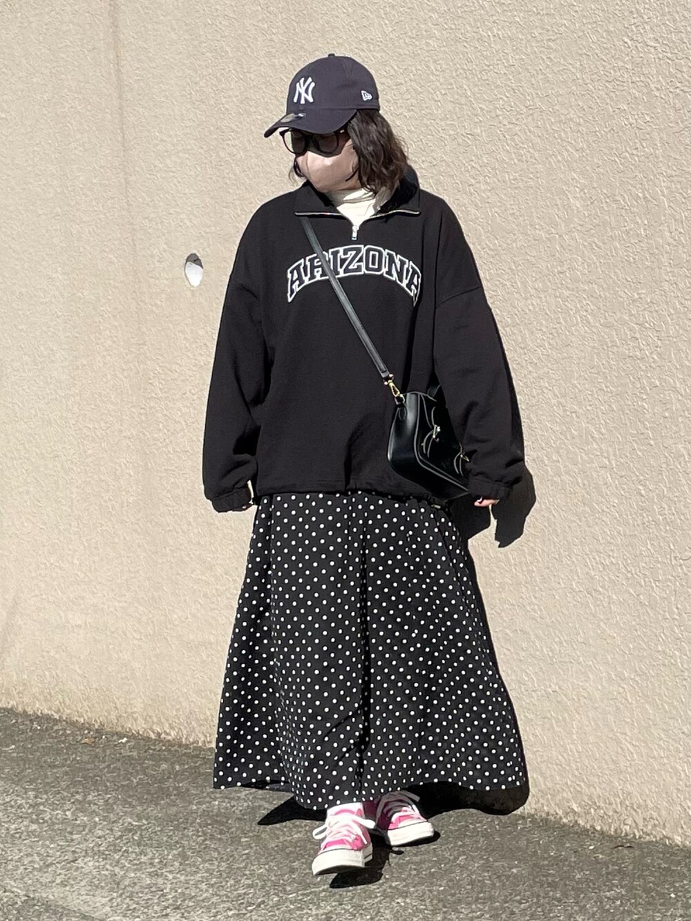 ブラック系のスウェット、ブラック系のスカート、ピンク系のスニーカーを着用したレディースの冬コーディネートの3枚目の写真