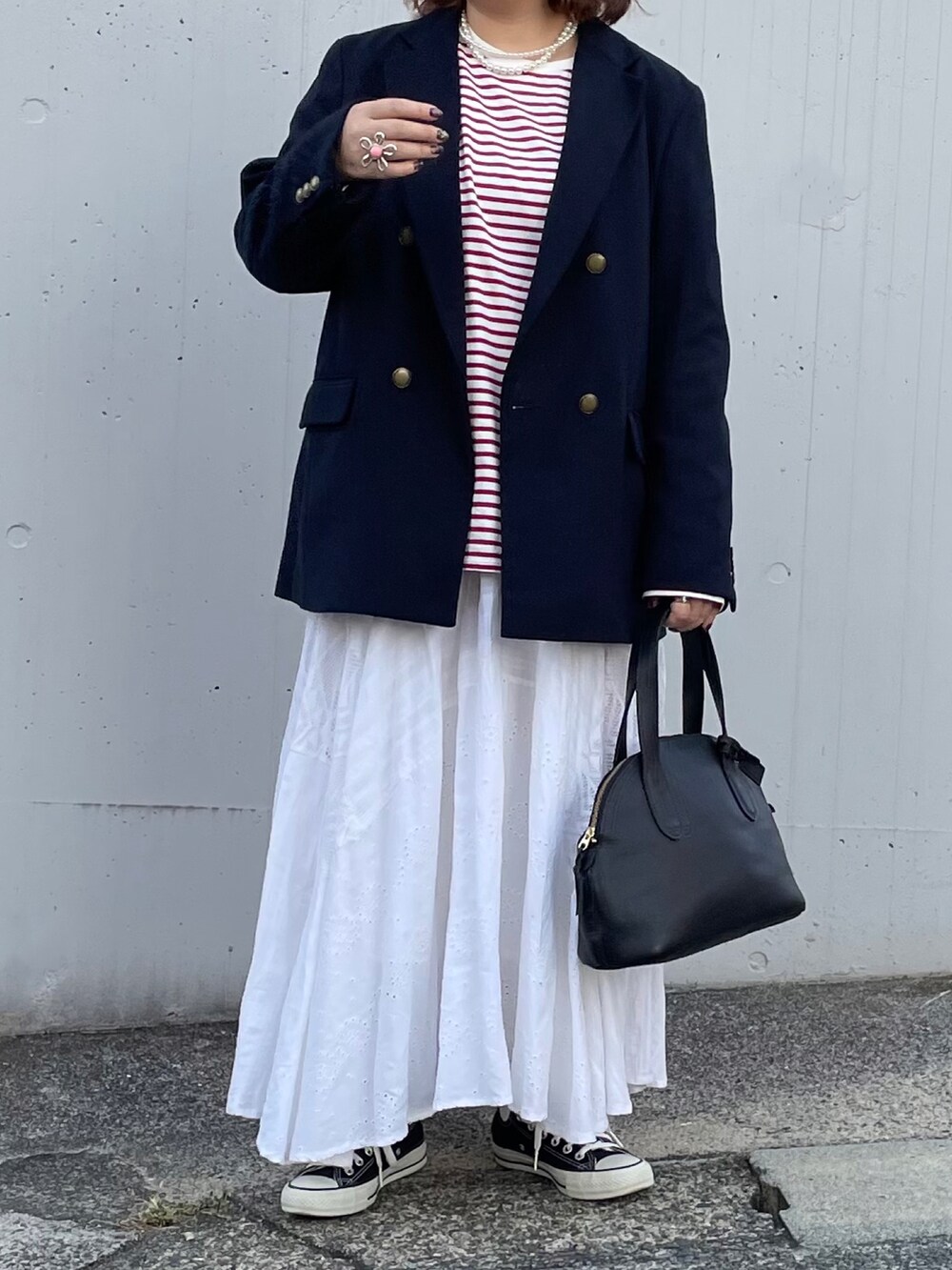 ブラック系のジャケット/アウター、ブラック系のボストンバッグ、ホワイト系のスカートを着用したレディースの秋コーディネートの2枚目の写真
