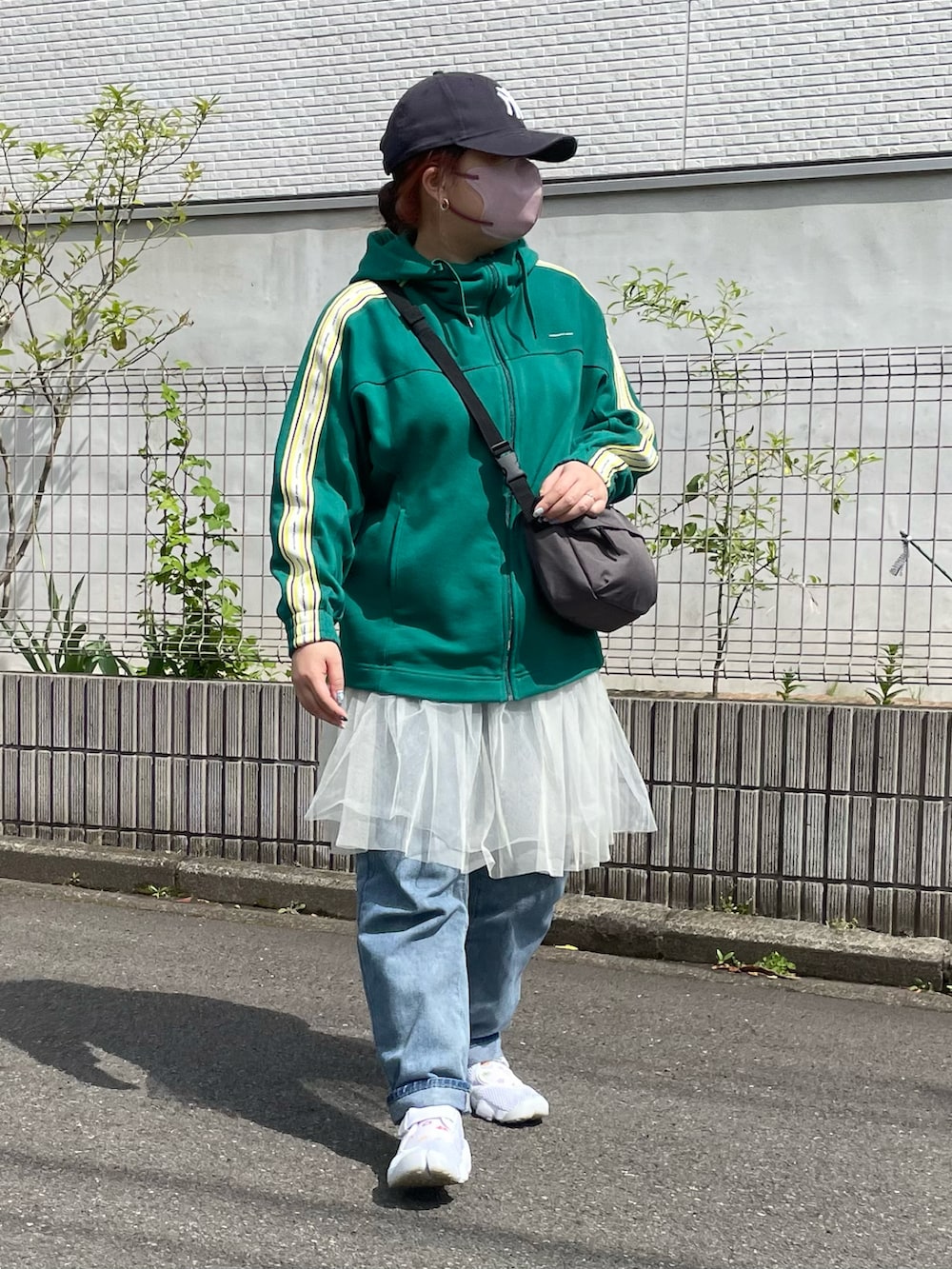 ホワイト系のスカート、ホワイト系のサンダル、ブルー系のキャップを着用したレディースの春コーディネートの2枚目の写真