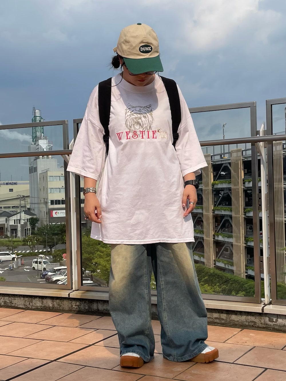ホワイト系のTシャツ/カットソー、ブルー系のデニムパンツ、ホワイト系のスニーカーを着用したレディースの夏コーディネートの2枚目の写真