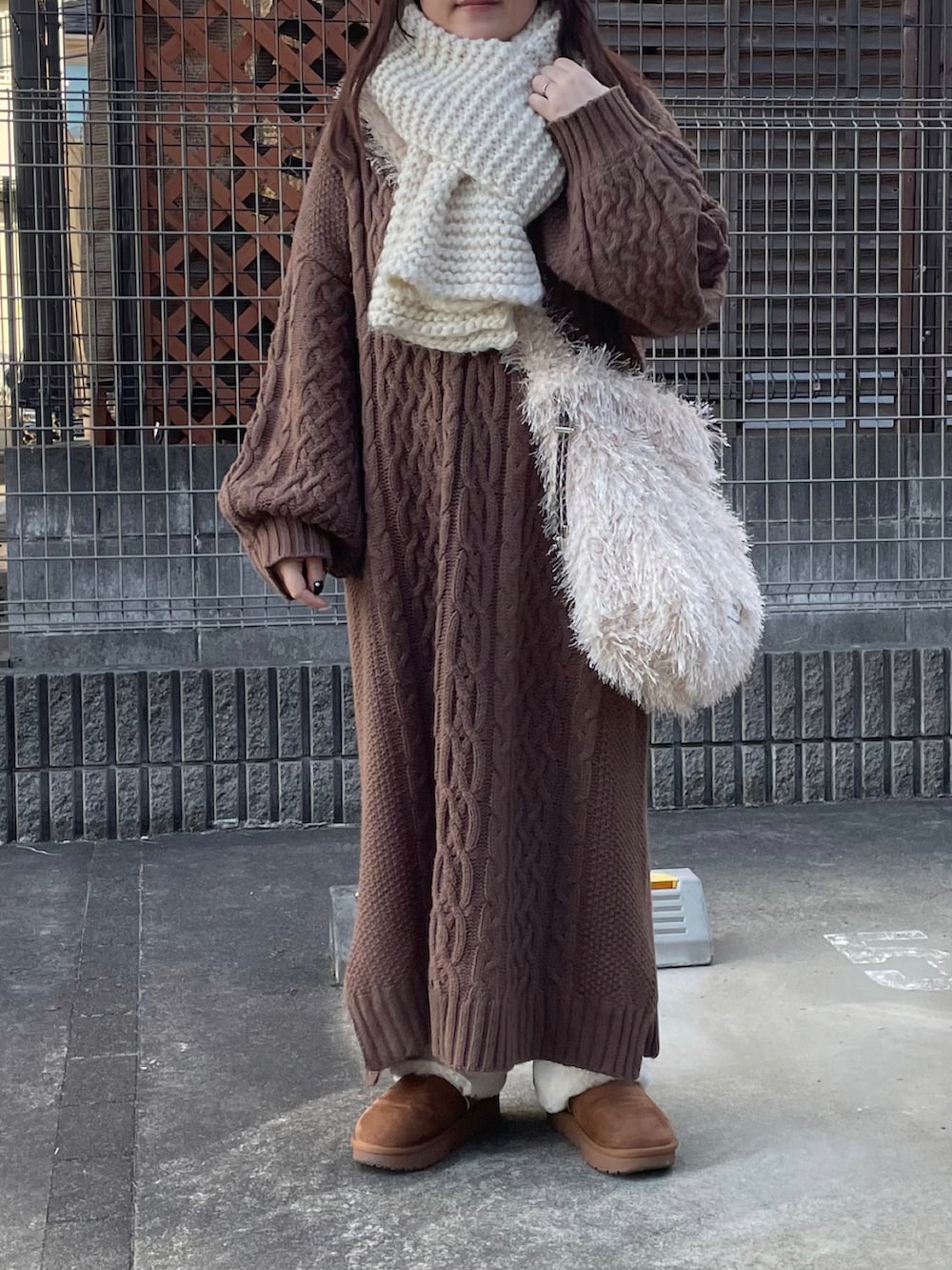 ベージュ系のシューズ、ベージュ系のショルダーバッグ、ホワイト系のマフラーを着用したレディースの冬コーディネートの2枚目の写真