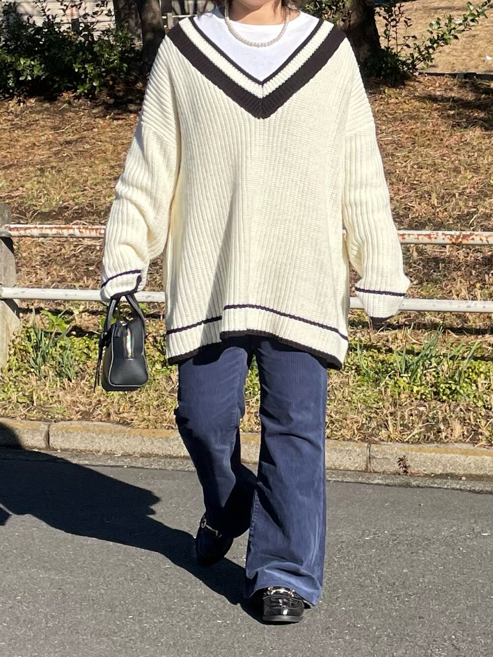 ホワイト系のニット/セーター、ブルー系のパンツ、ホワイト系のトートバッグを着用したレディースの冬コーディネートの2枚目の写真