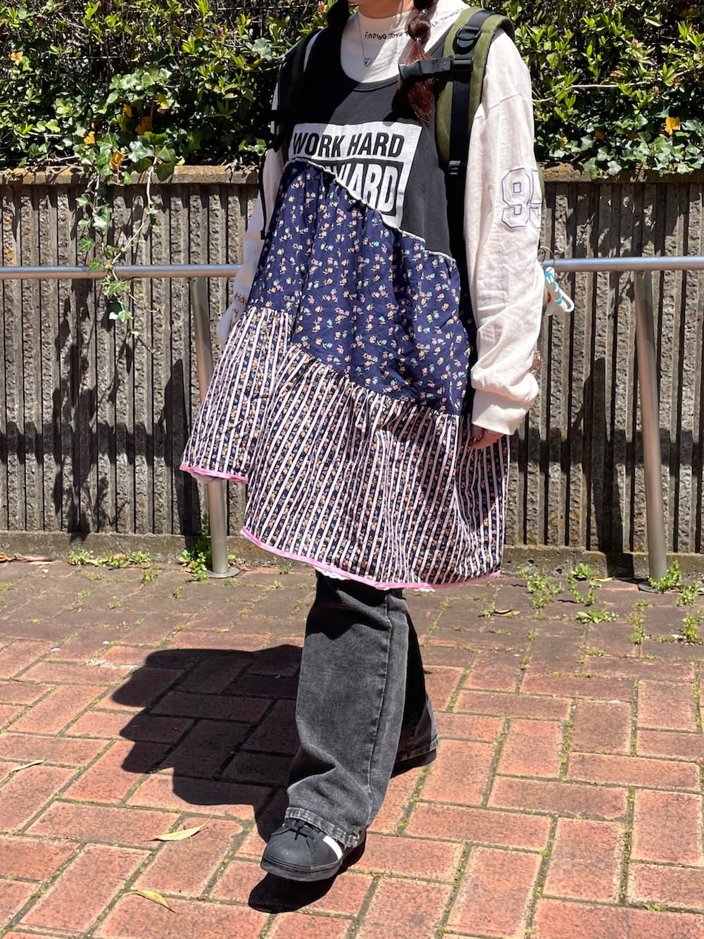 ブラック系のワンピース、ホワイト系のTシャツ/カットソー、グリーン系のバックパック/リュックを着用したレディースの春コーディネートの2枚目の写真