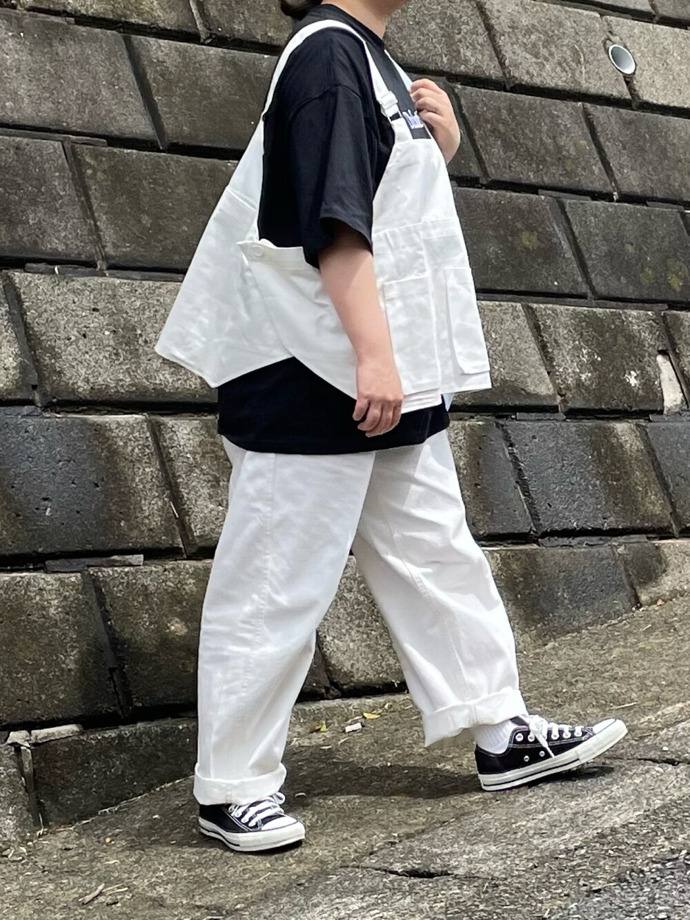 ブラック系のTシャツ/カットソー、ブラック系のスニーカーを着用したレディースの春コーディネートの3枚目の写真