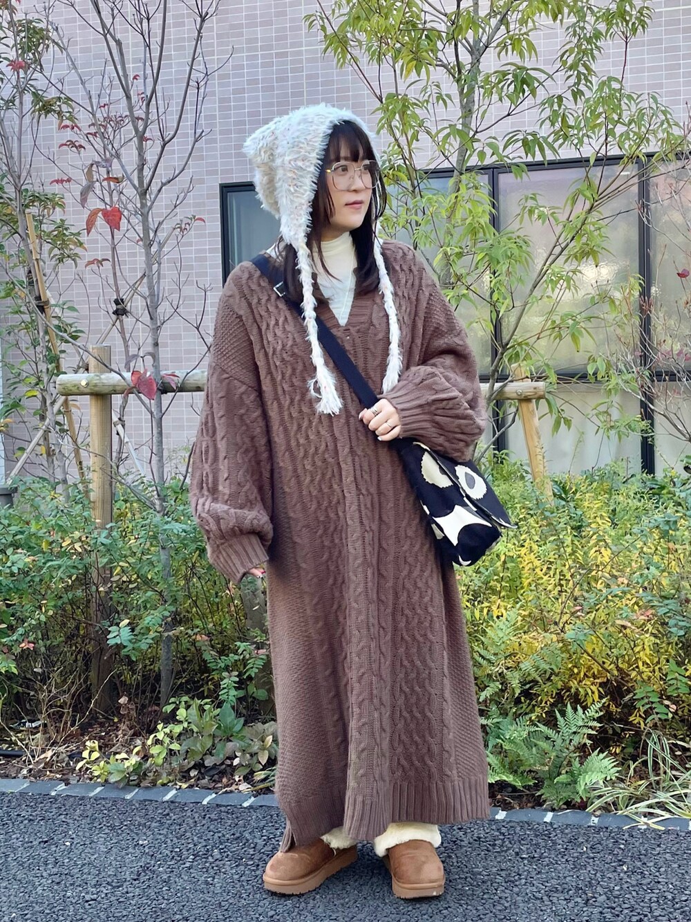 ブラック系のショルダーバッグ、ベージュ系のシューズ、ホワイト系のTシャツ/カットソーを着用したレディースの冬コーディネートの2枚目の写真