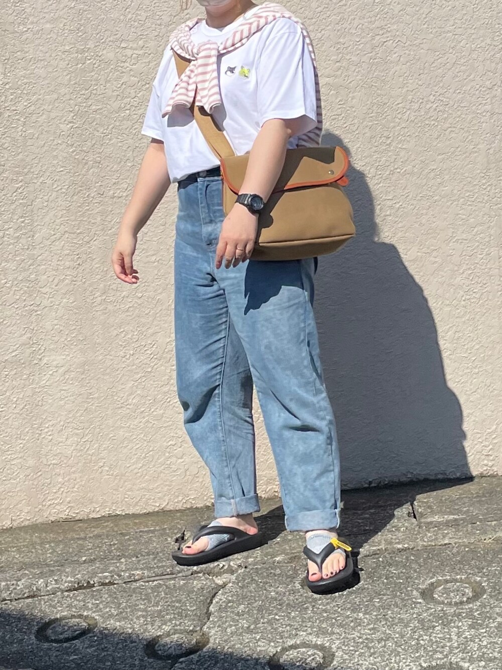 ベージュ系のショルダーバッグ、ホワイト系のTシャツ/カットソーを着用したレディースの夏コーディネートの2枚目の写真