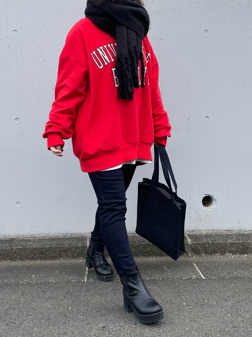 レッド系のスウェット、ブルー系のパンツ、ブルー系のトートバッグを着用したレディースの冬コーディネートの4枚目の写真