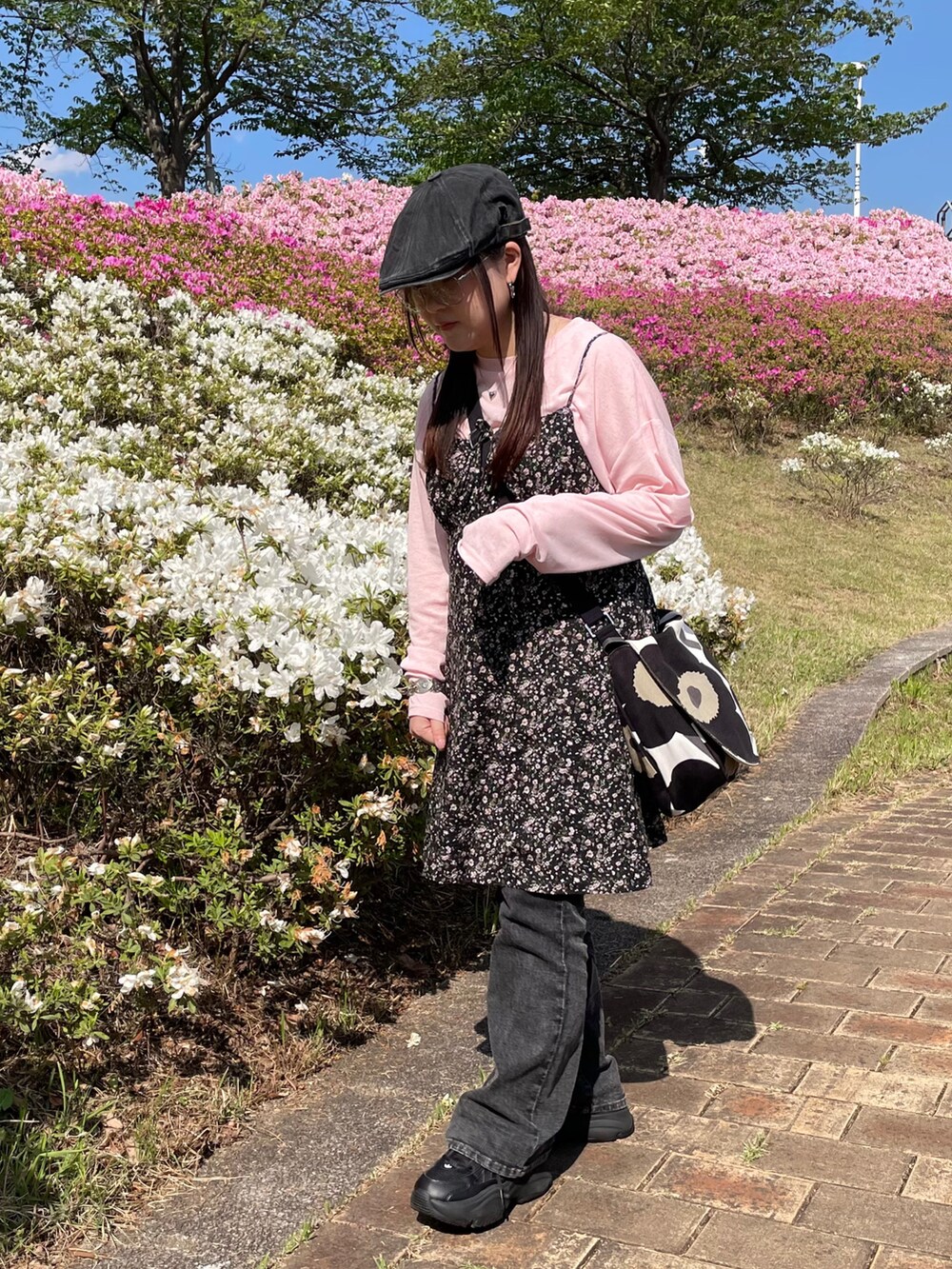 ピンク系のTシャツ/カットソー、ブラック系のスニーカー、ブラック系のハンチング/ベレー帽を着用したレディースの春コーディネートの2枚目の写真