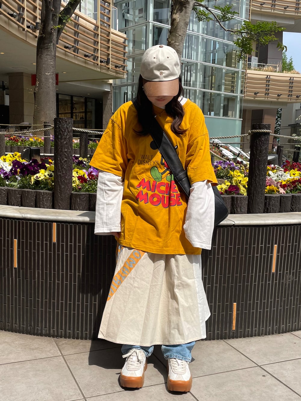 ブラック系のTシャツ/カットソー、ホワイト系のスカート、ホワイト系のスニーカーを着用したレディースの春コーディネートの2枚目の写真