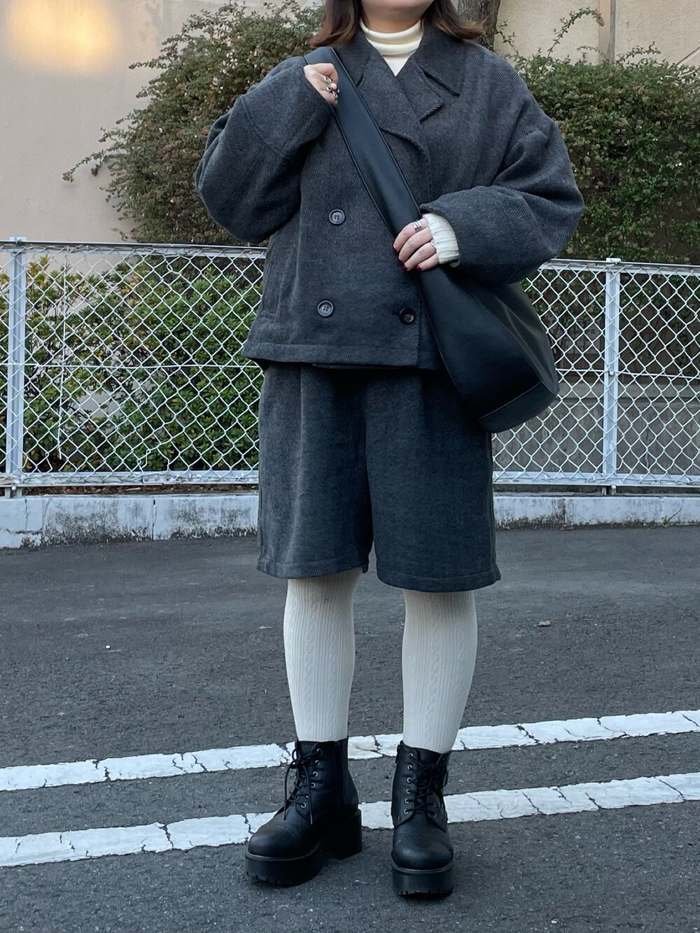 ブラック系のテーラードジャケット、ブラック系のその他パンツ、ブラック系のショルダーバッグを着用したレディースの冬コーディネートの4枚目の写真