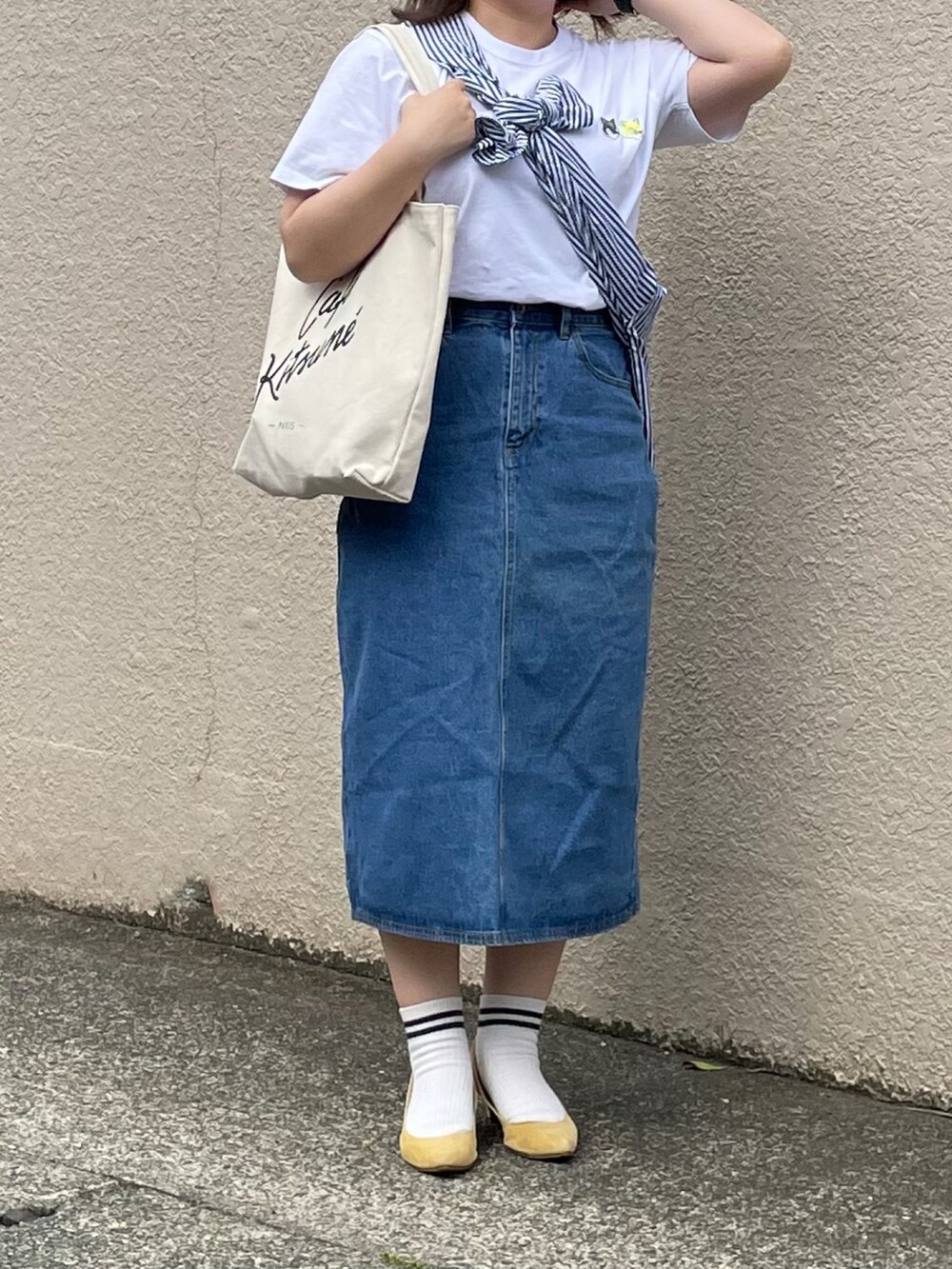 ホワイト系のTシャツ/カットソー、ブルー系のデニムスカート、イエロー系のパンプスを着用したレディースの夏コーディネートの3枚目の写真