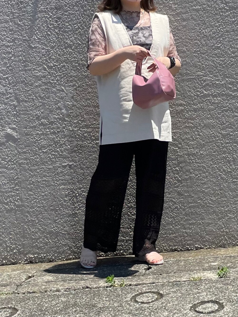 ホワイト系のベスト、ブラック系のその他パンツ、ピンク系のボストンバッグを着用したレディースの夏コーディネートの2枚目の写真