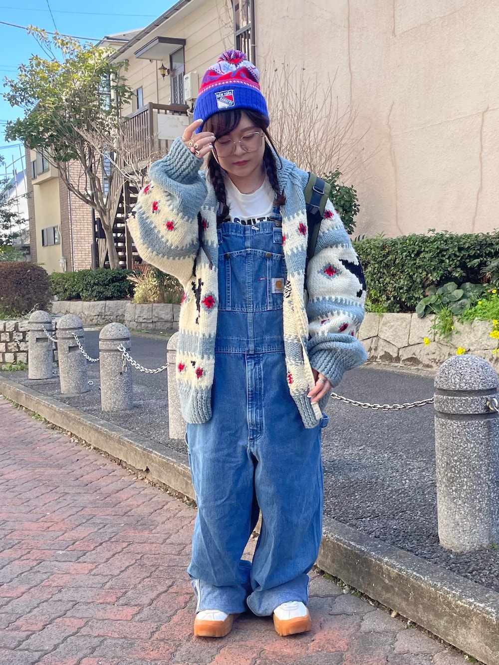 ブルー系のカーディガン/ボレロ、ブルー系のサロペット/オーバーオール、ホワイト系のスニーカーを着用したレディースの春コーディネートの2枚目の写真