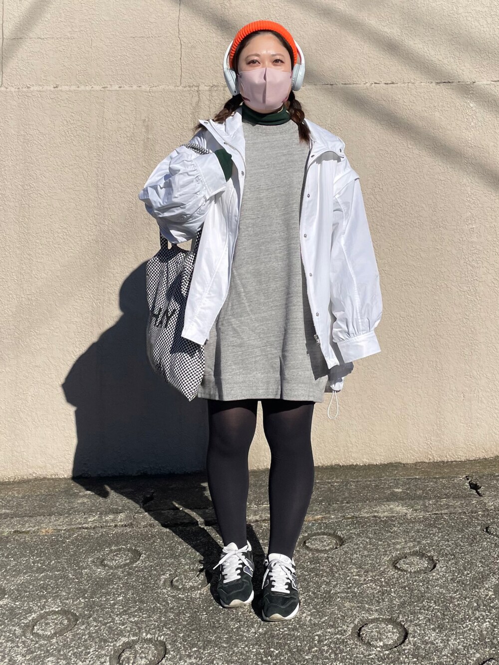 グレー系のワンピース、ブルー系のスニーカー、ホワイト系のブルゾンを着用したレディースの冬コーディネートの2枚目の写真
