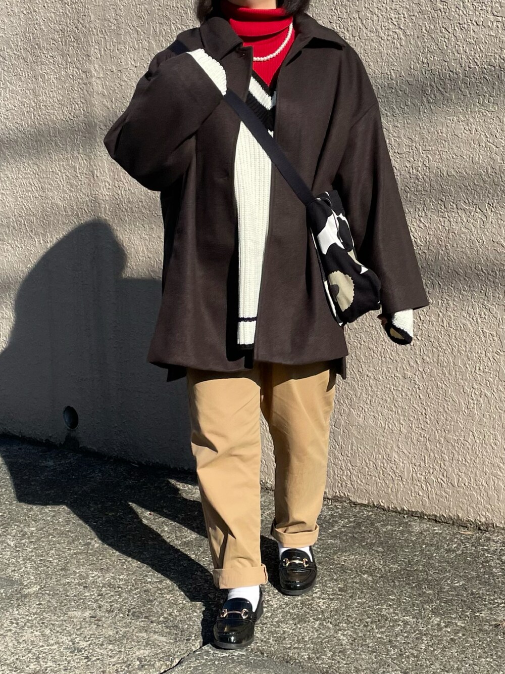 ホワイト系のニット/セーター、レッド系のニット/セーター、ブラック系のショルダーバッグを着用したレディースの冬コーディネートの2枚目の写真