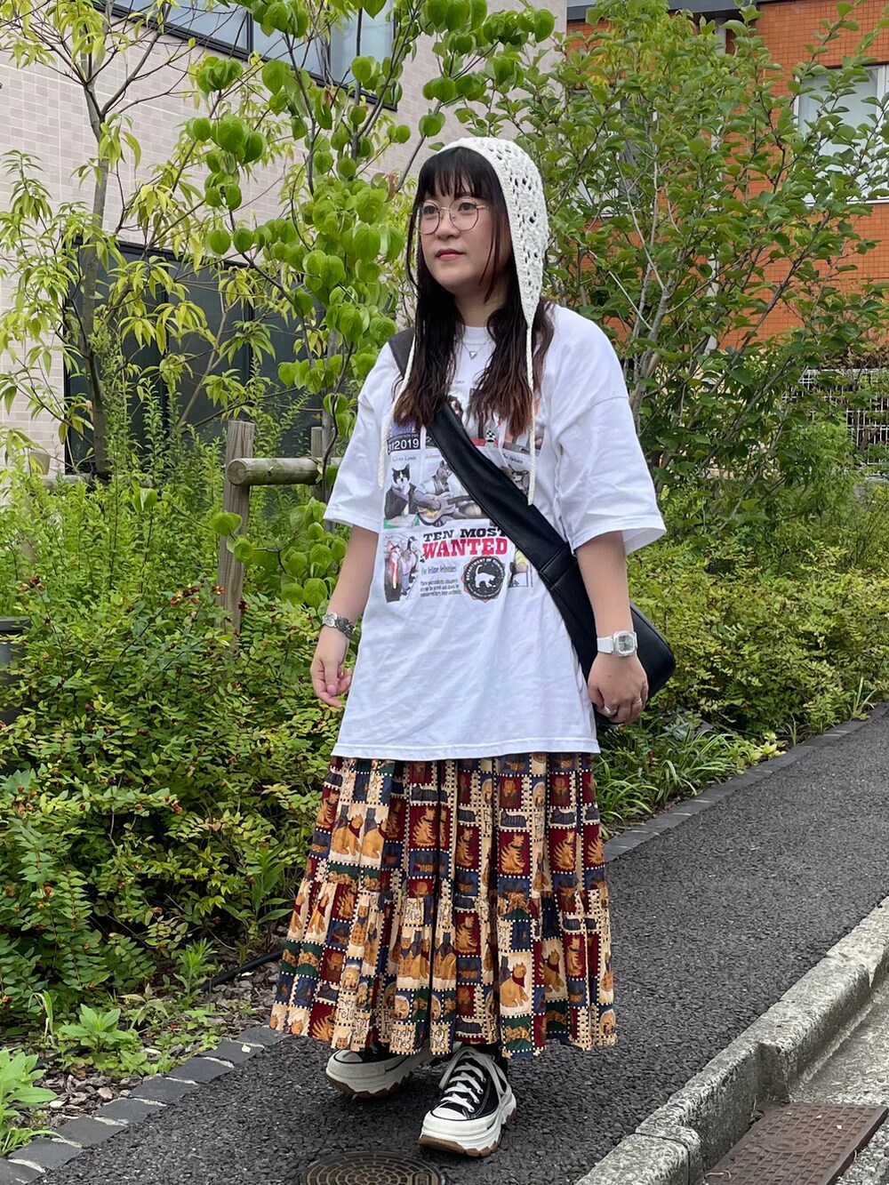 ブラック系のスニーカー、ホワイト系のTシャツ/カットソー、ブラウン系のスカートを着用したレディースの夏コーディネートの2枚目の写真