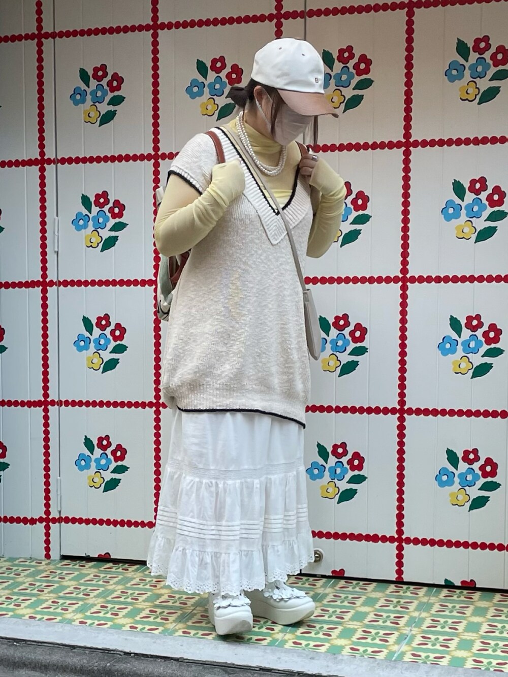 ホワイト系のベスト、ホワイト系のスカート、イエロー系のシャツ/ブラウスを着用したレディースの秋コーディネートの2枚目の写真