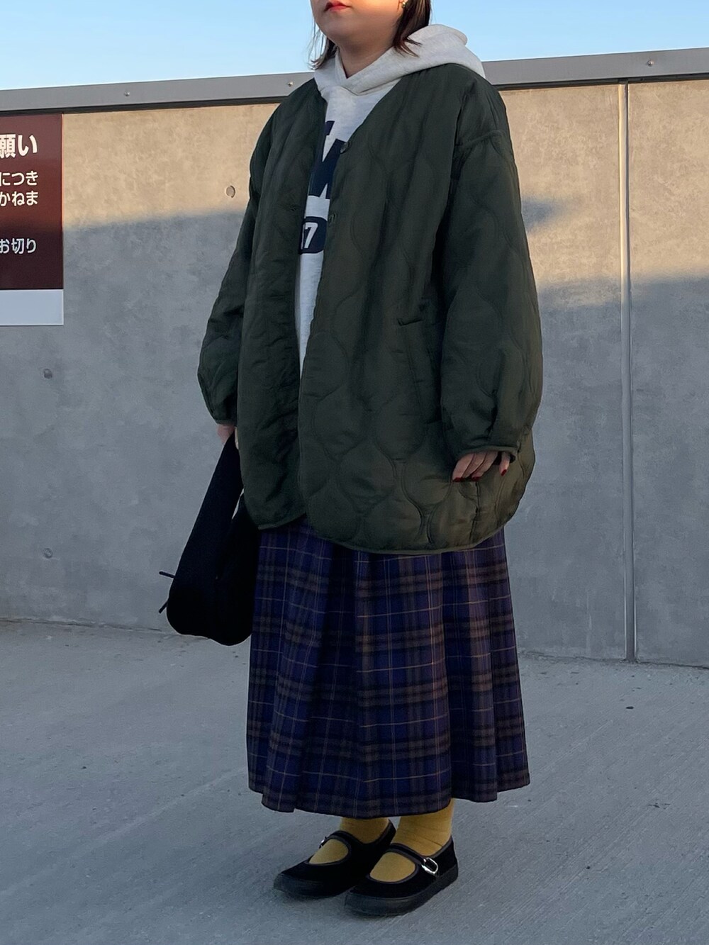 ベージュ系のパーカー、ブルー系のスカート、ブラック系のバレエシューズを着用したレディースの冬コーディネートの2枚目の写真