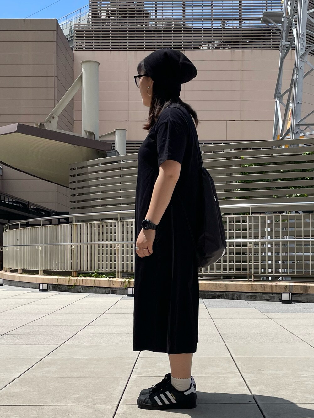 ブラック系のワンピース/ドレス、ブラック系のスニーカー、ブラック系のバックパック/リュックを着用したレディースの夏コーディネートの2枚目の写真