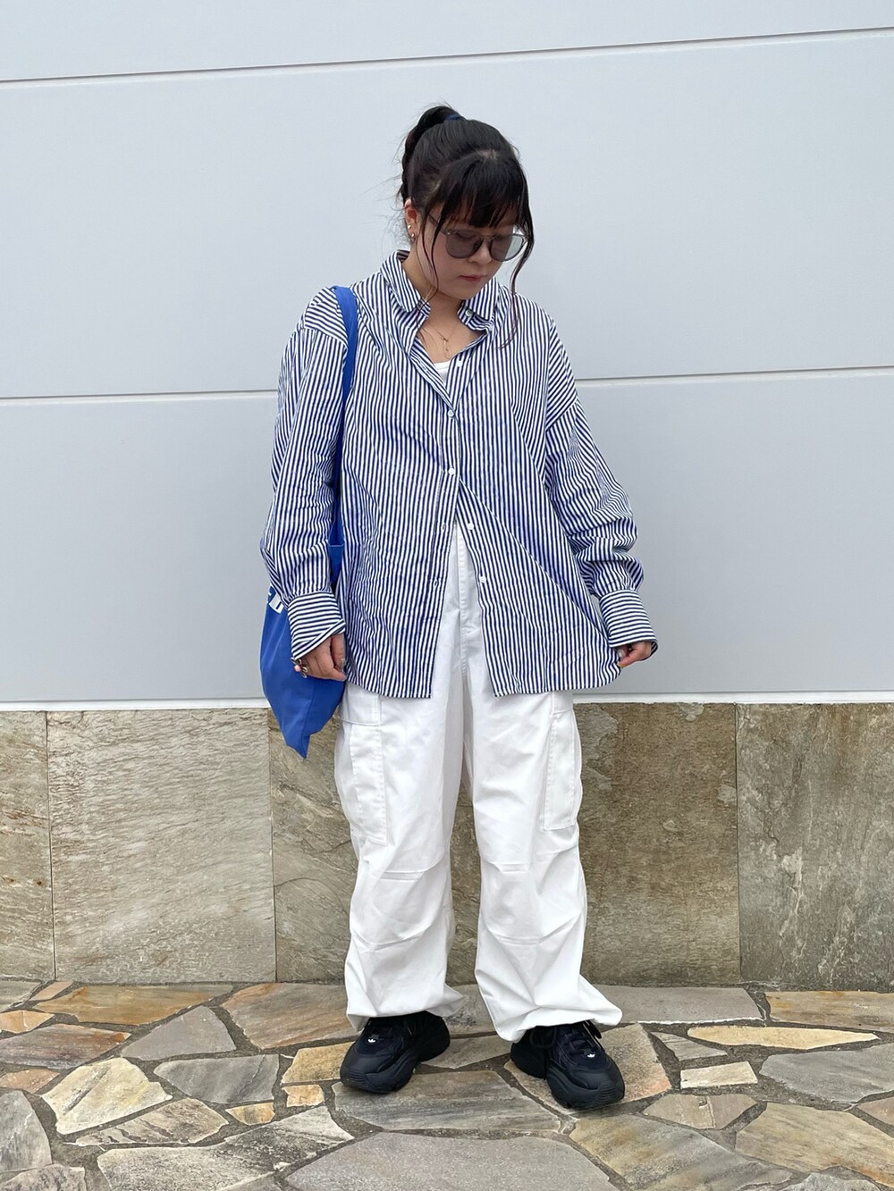 ブルー系のシャツ/ブラウス、ブラック系のカーゴパンツ、ブラック系のスニーカーを着用したレディースの春コーディネートの2枚目の写真