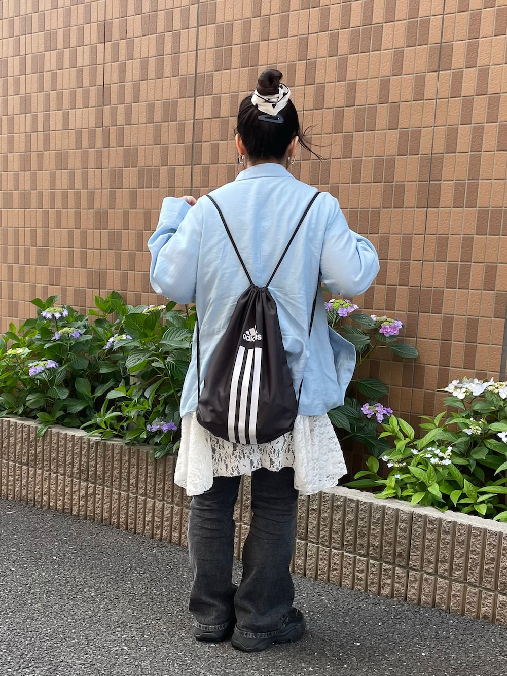 ブルー系のテーラードジャケット、ブラック系のバックパック/リュック、ブラック系のスニーカーを着用したレディースの夏コーディネートの2枚目の写真