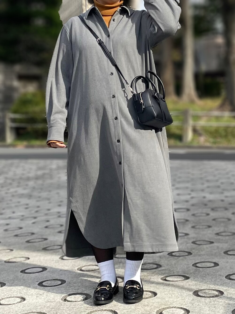 グレー系のワンピース、イエロー系のニット/セーター、ブラック系のボストンバッグを着用したレディースの秋コーディネートの2枚目の写真