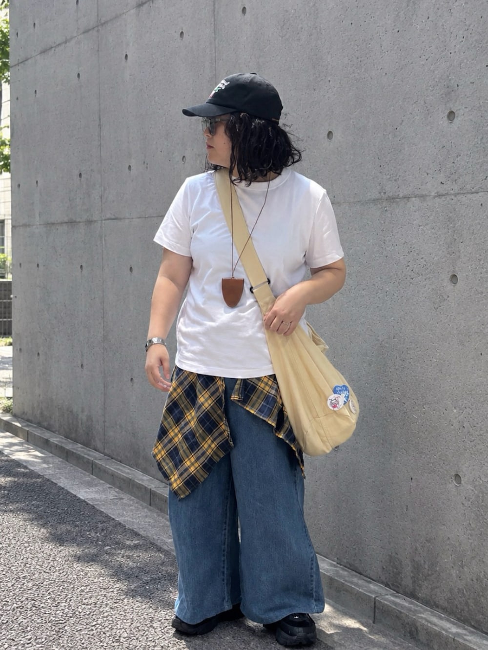 ブラック系のスニーカー、ホワイト系のTシャツ/カットソー、ブラウン系のサングラスを着用したレディースの秋コーディネートの2枚目の写真