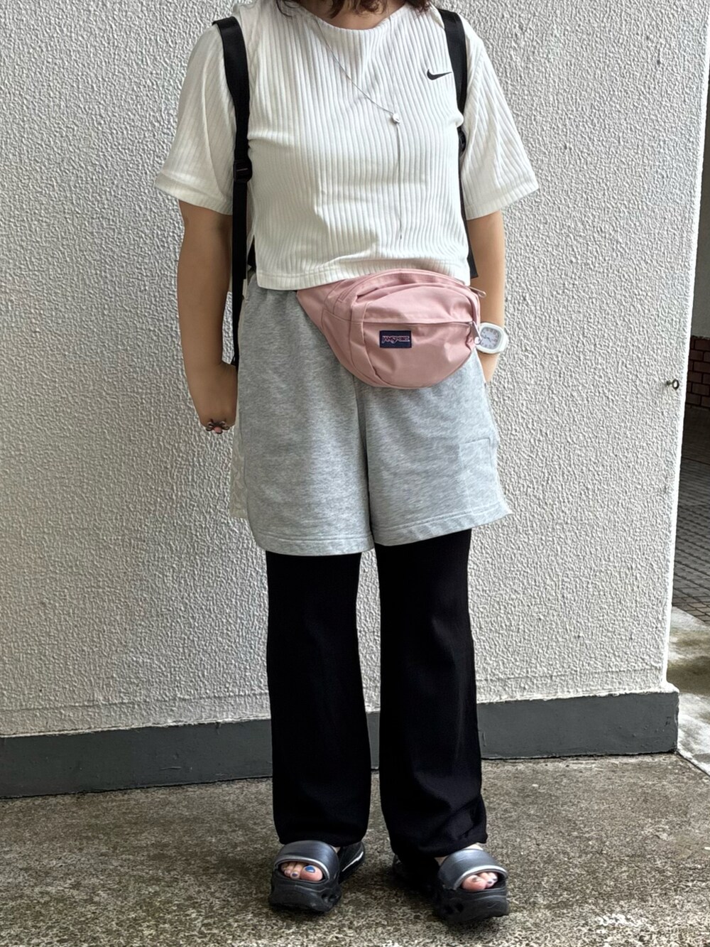 グレー系のサンダル、グレー系のパンツ、ピンク系のボディバッグ/ウエストポーチを着用したレディースの秋コーディネートの2枚目の写真