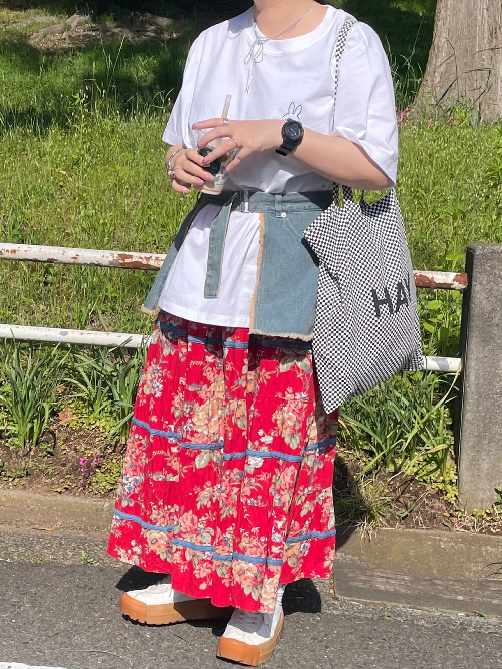 ブルー系のスカート、レッド系のスカート、ホワイト系のスニーカーを着用したレディースの春コーディネートの2枚目の写真