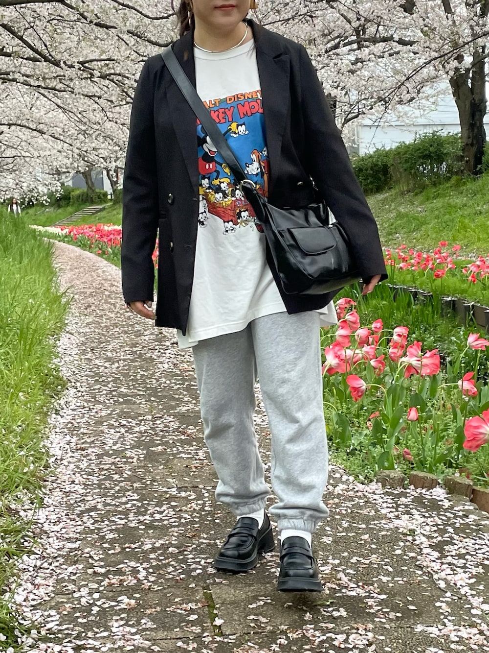 ブラック系のテーラードジャケット、グレー系のパンツ、ホワイト系のTシャツ/カットソーを着用したレディースの春コーディネートの2枚目の写真