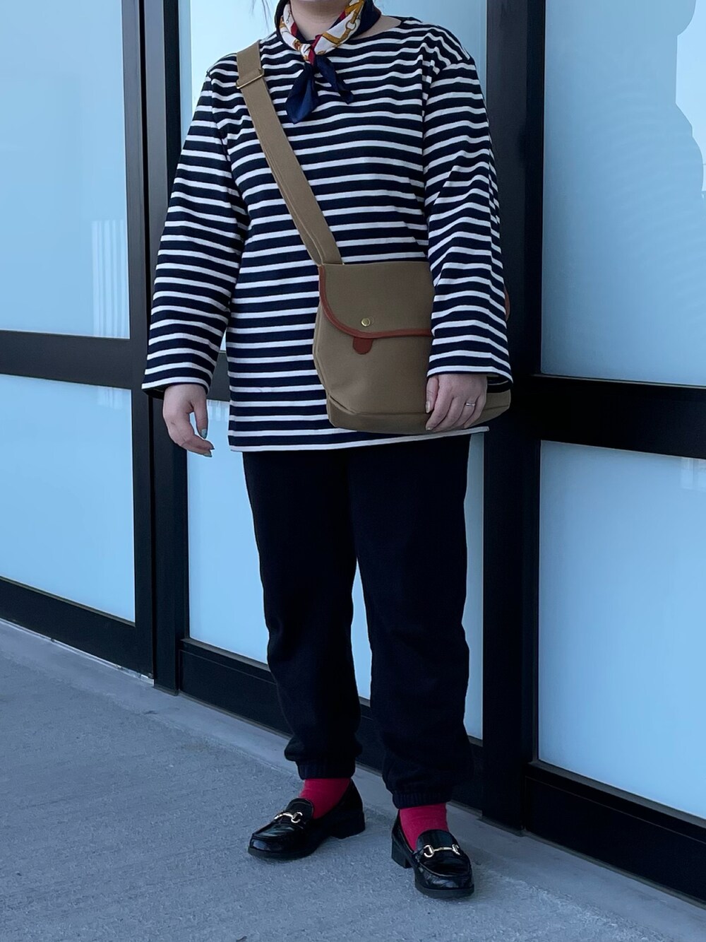 ベージュ系のショルダーバッグ、ブラック系のローファーを着用したレディースの春コーディネートの2枚目の写真