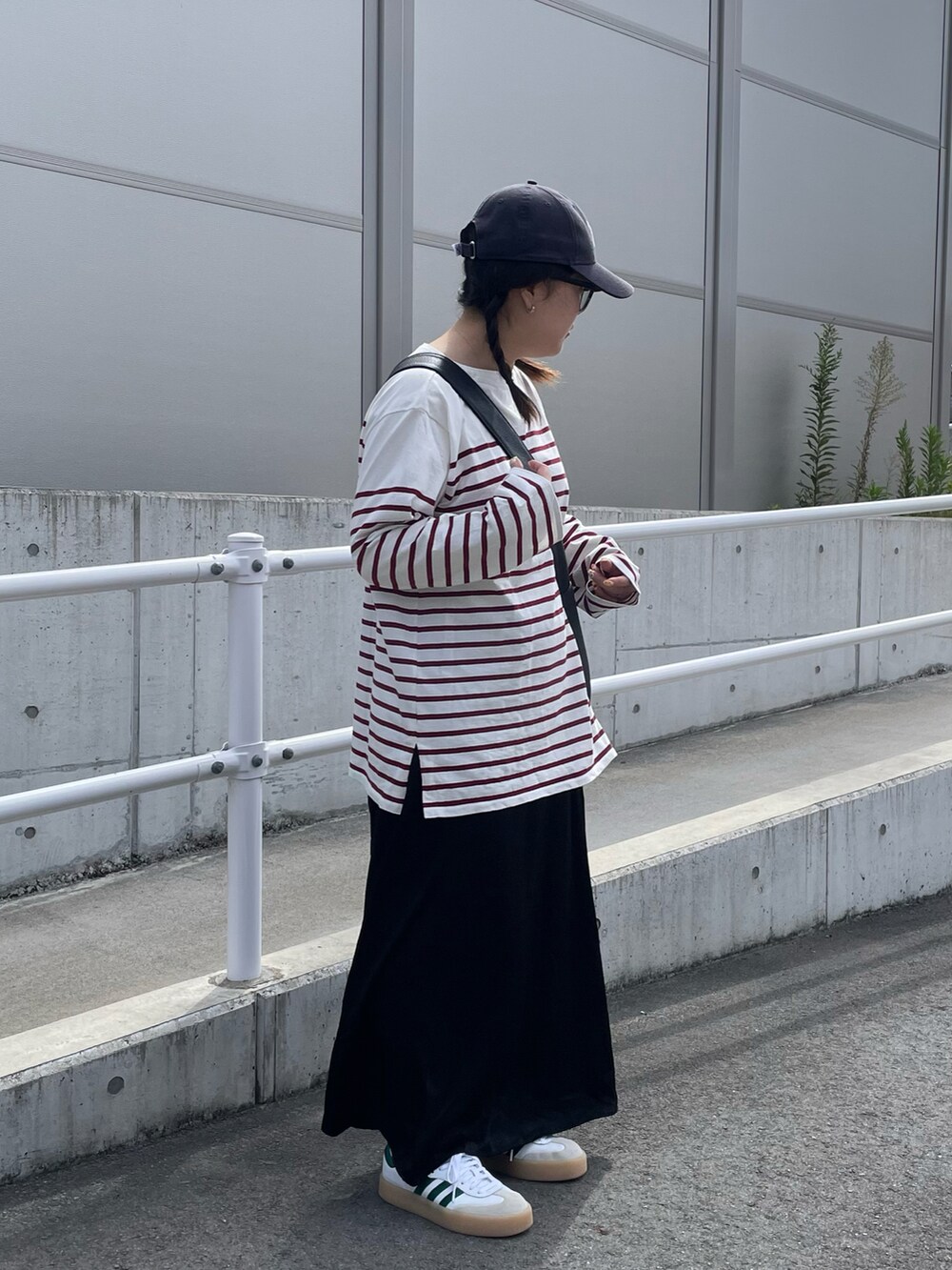 ピンク系のTシャツ/カットソー、ブラック系のショルダーバッグ、ブラック系のスカートを着用したレディースの秋コーディネートの2枚目の写真