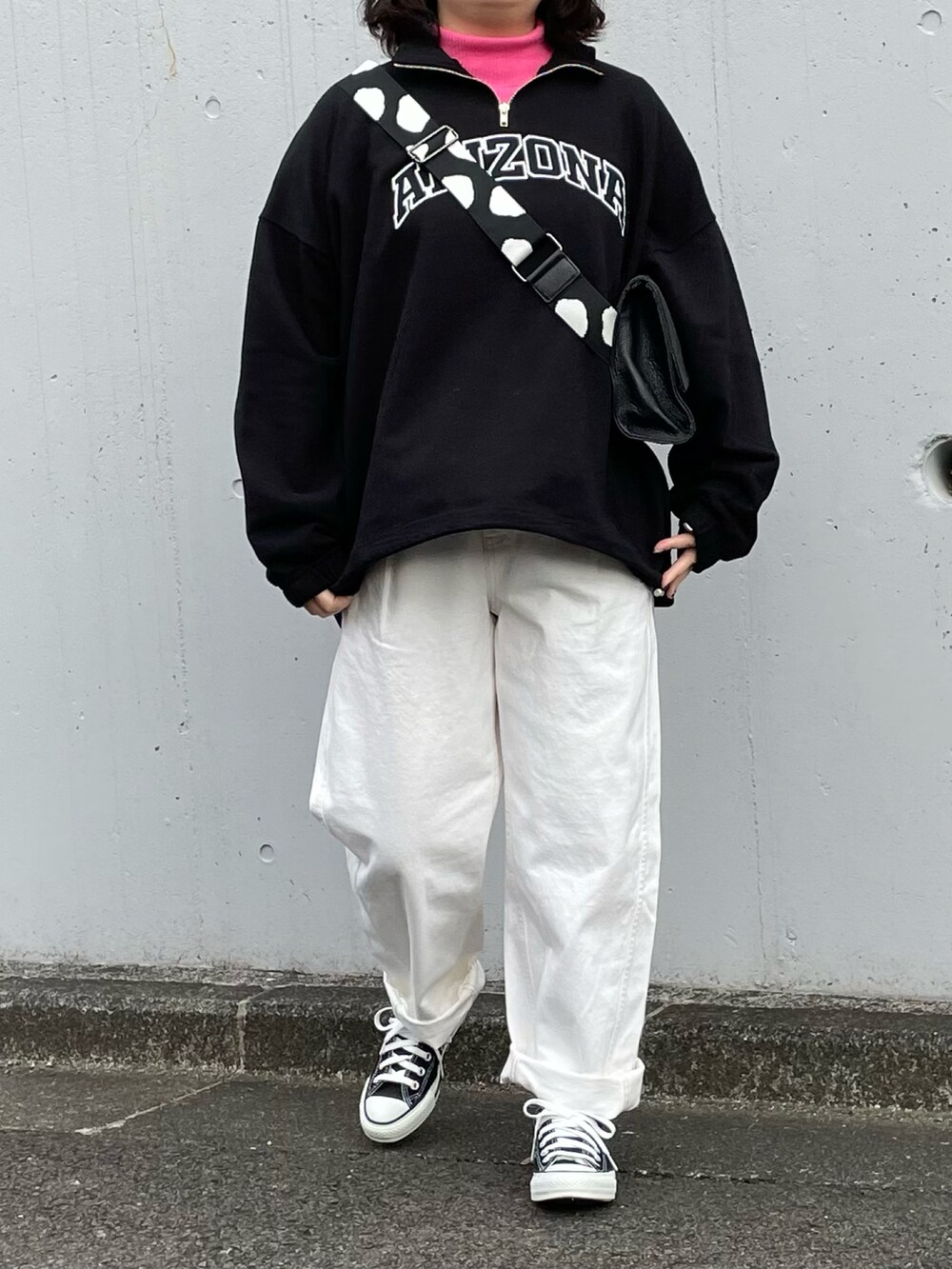 ブラック系のスウェット、ピンク系のニット/セーター、ホワイト系のパンツを着用したレディースの冬コーディネートの2枚目の写真